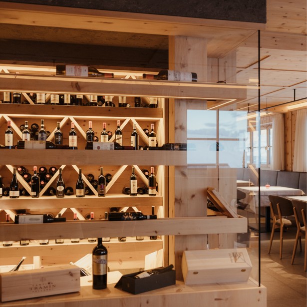 Un armadio elegante in legno vero nella sala da pranzo, che espone diverse bottiglie di vino.