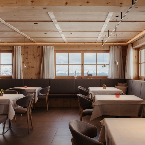 L'accogliente sala da pranzo con diversi tavoli e una vetrata crea un'atmosfera piacevole.