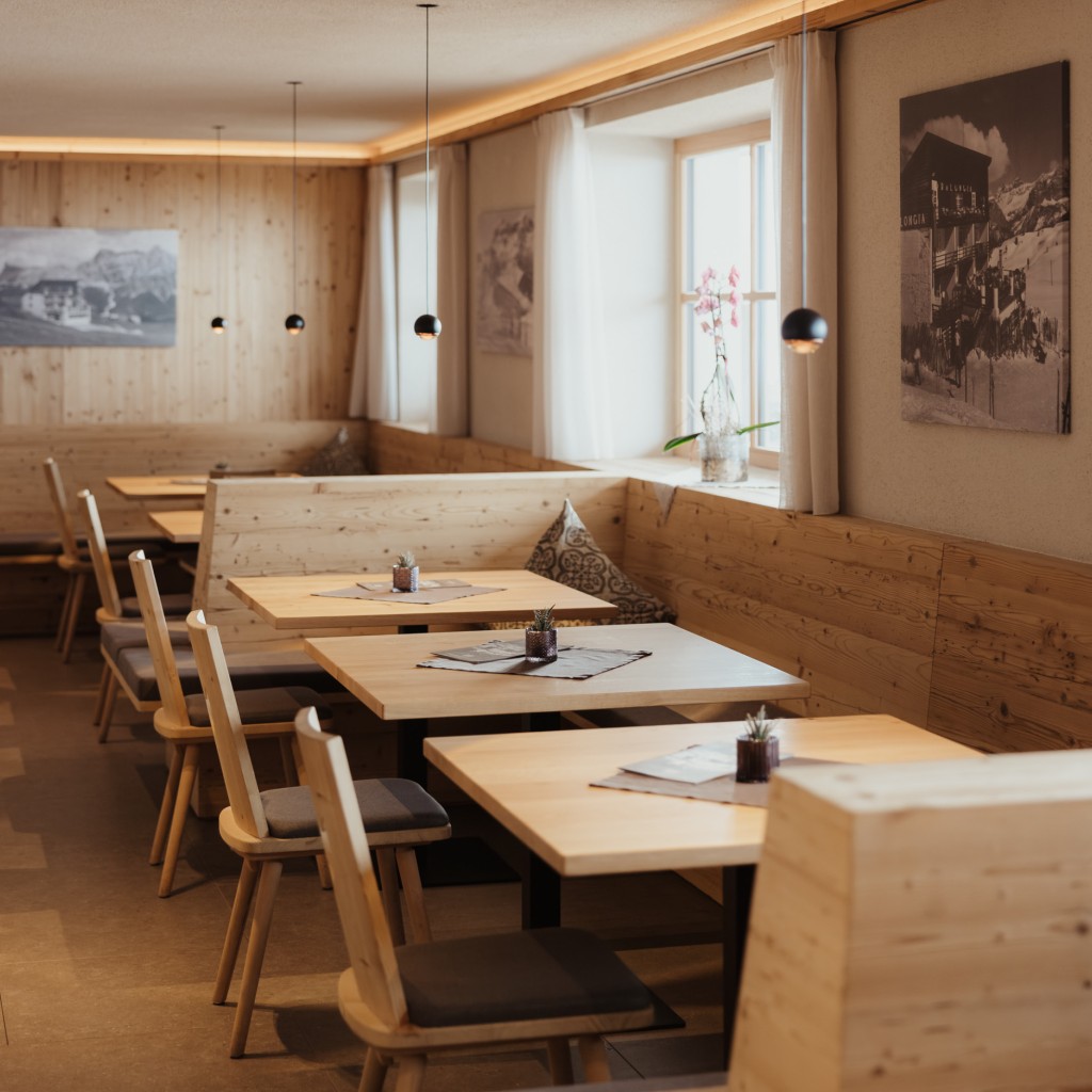 I tavoli e le sedie di legno massello nella sala da pranzo si abbinano al design semplice dell'arredamento.