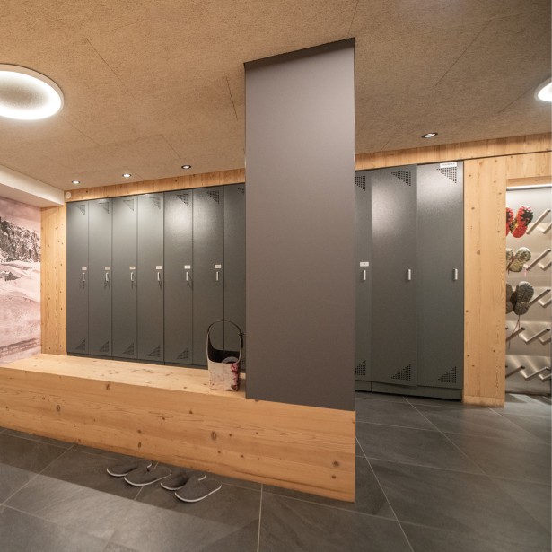 Un locale d'asciugatura arredato in modo semplice con una parete di legno rivestita e armadietti.