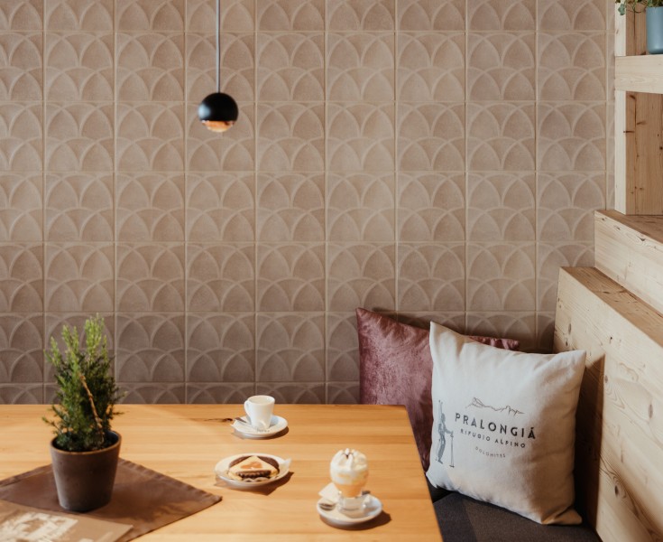 Un tavolo di legno vero nell'angolo, fatto di legno di pino cembro, crea un'atmosfera accogliente e sembra invitante. Sul tavolo ci sono due bicchieri di gustoso Bombardino.