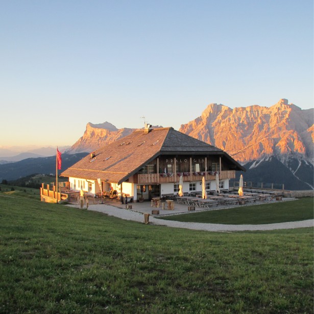The more modern Pralongià Mountain Inn, as it looked before the last renovation. It is the only building in the middle of a sunny and solitary alpine meadow high up in the South Tyrolean mountains.